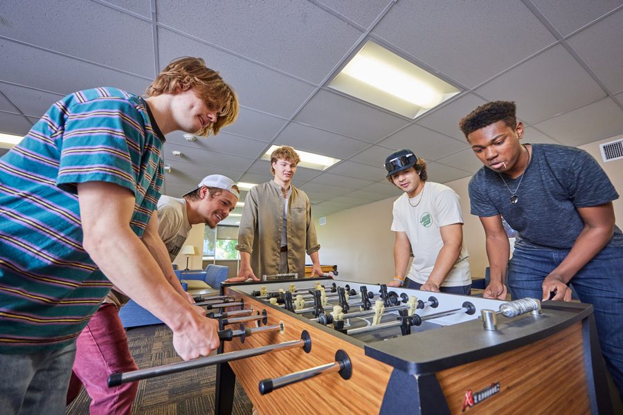 Five CBU students playing foosball on campus