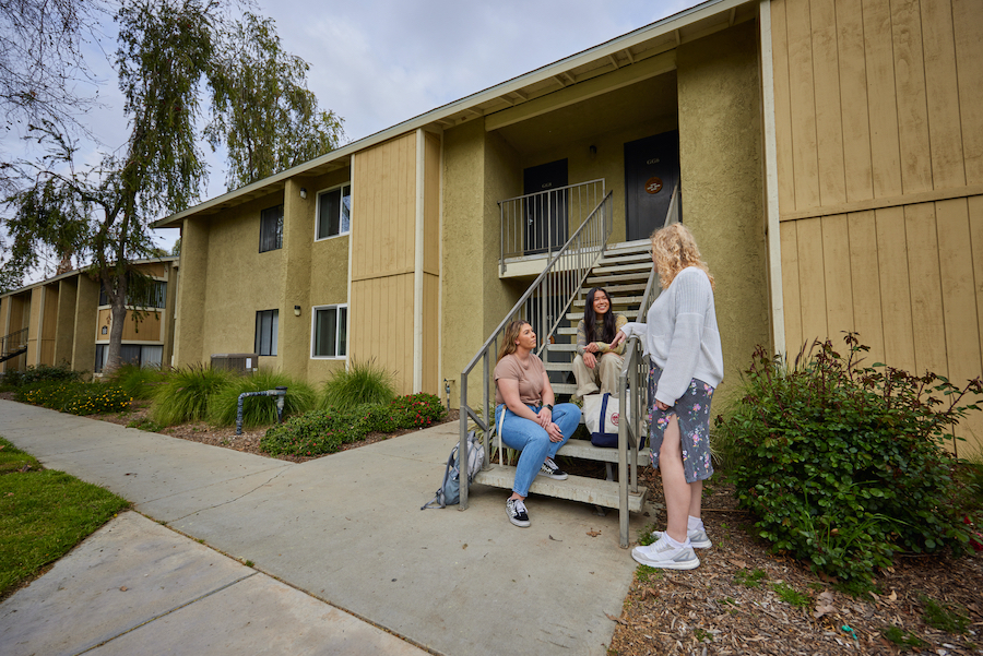 students in front of apartments