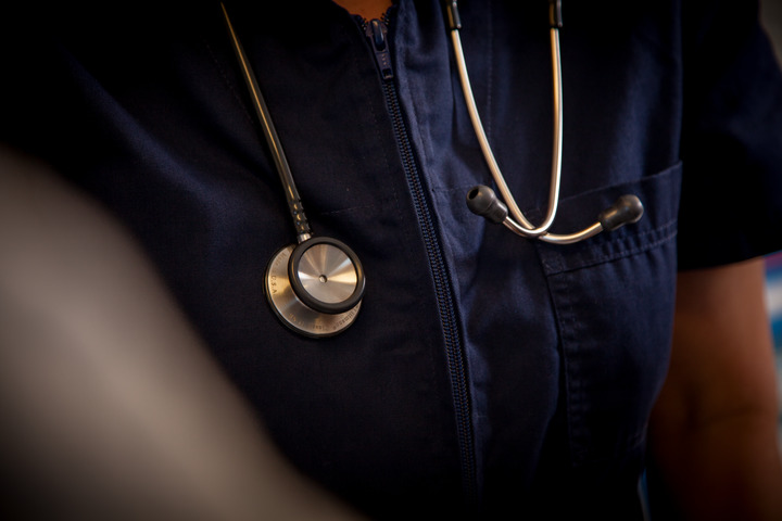 A stethoscope draped around a physician assistant's shoulders