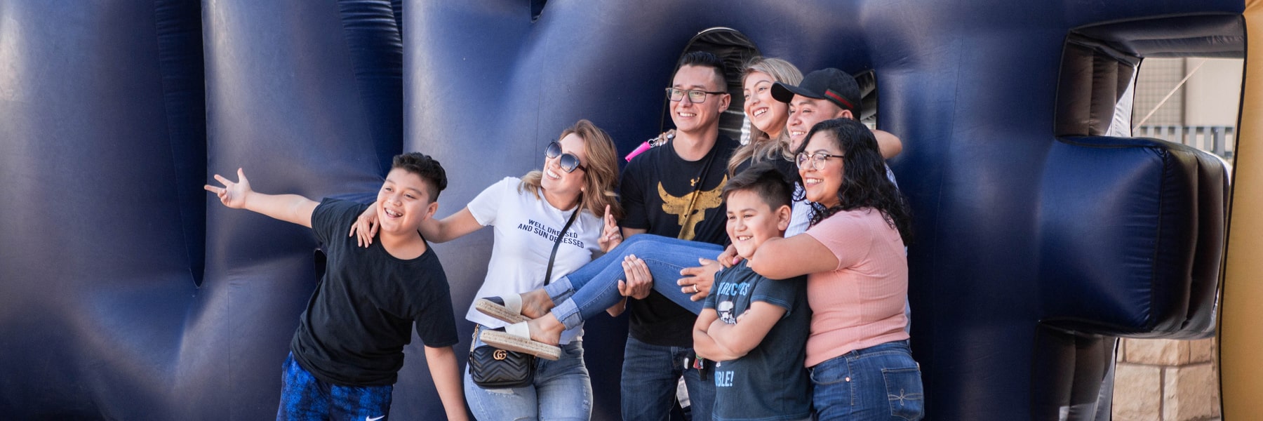 CBU student and their family posing in front of a blow up Lancers sign