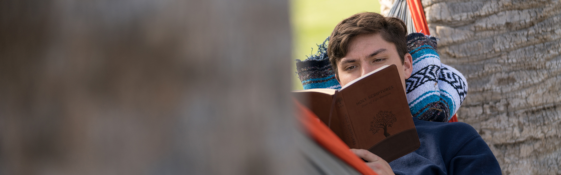 boy reading in hammock