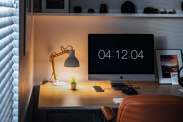 A student's desk with a computer and lamp.