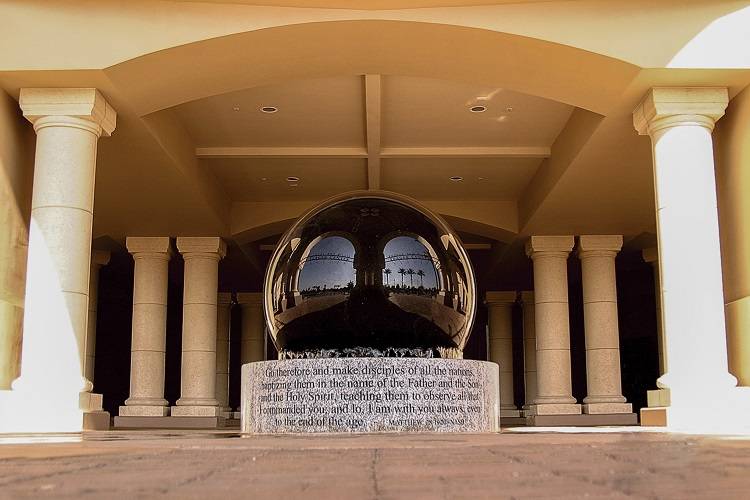 Art installation with a large reflective sphere sitting atop a stone base