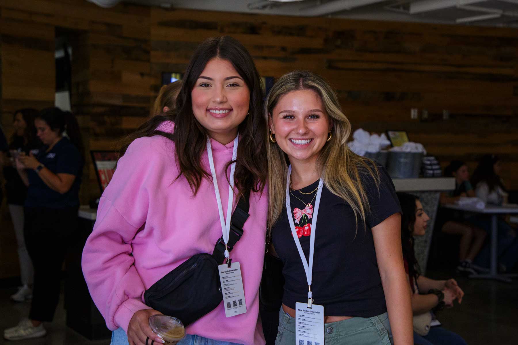 2 students posting with lanyards in dining area